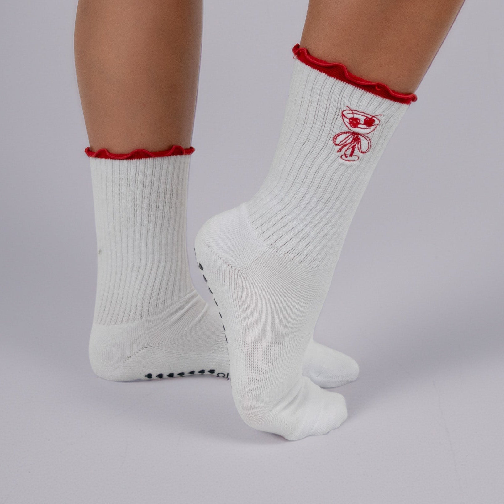 White socks with red trim worn by a person on a gray background