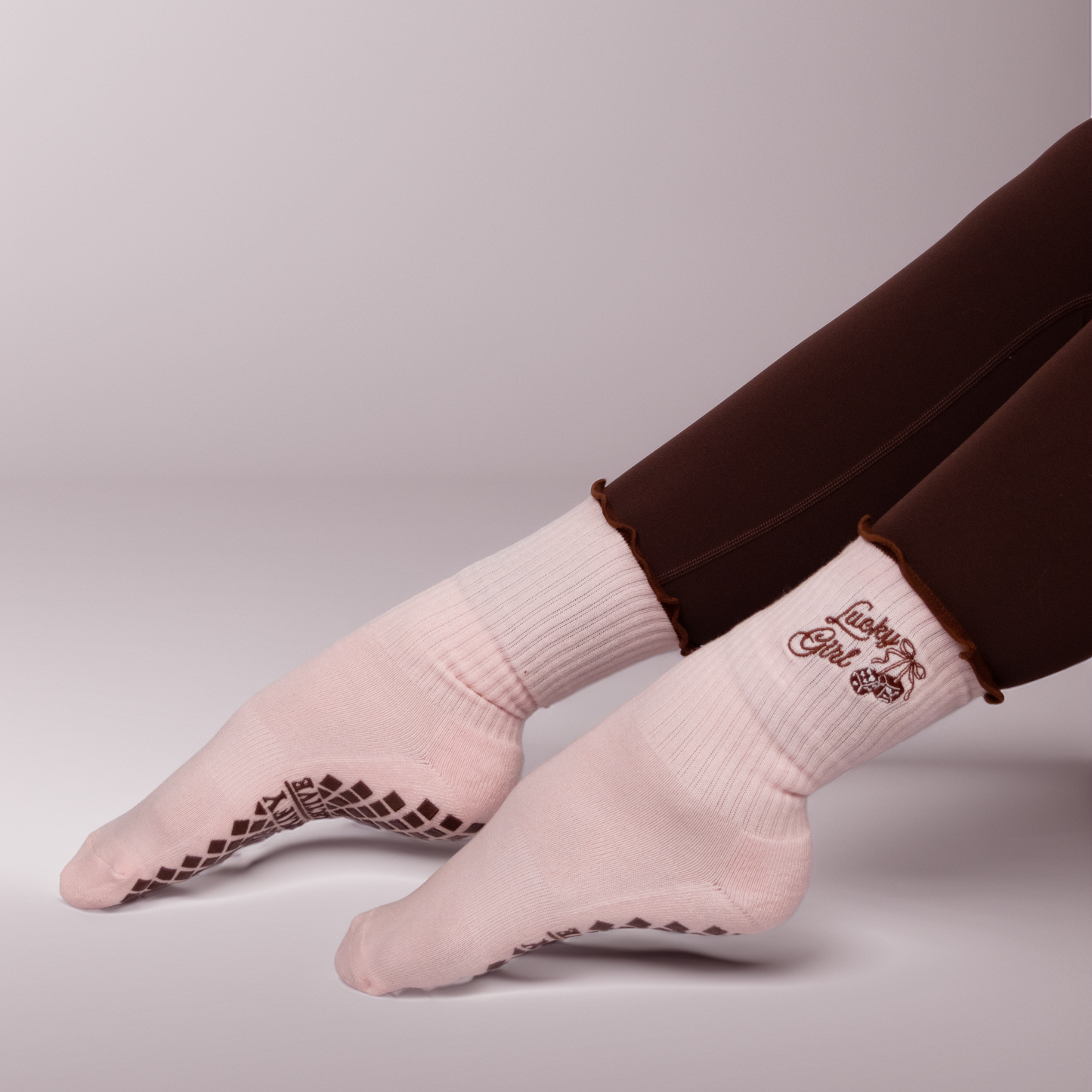 Light pink socks with black patterns worn by a person on a plain background