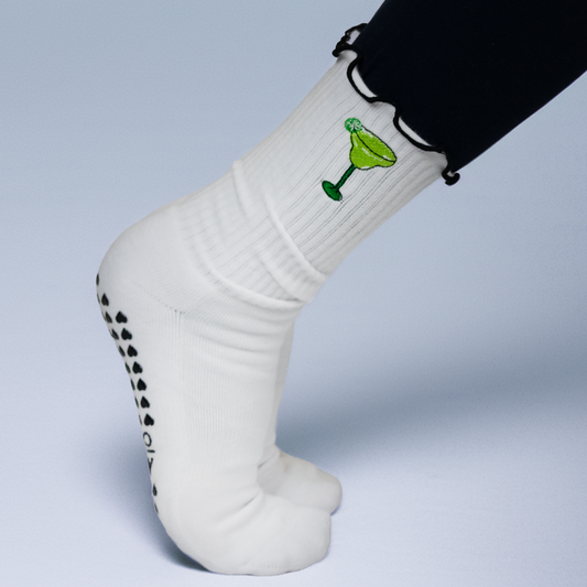White sock with a green cocktail graphic worn by a person on a light gray background